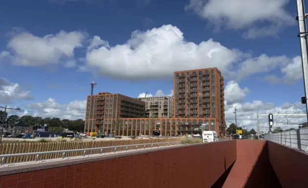 Nieuwe woongebouwen naast het spoor en een fietsonderdoorgang.