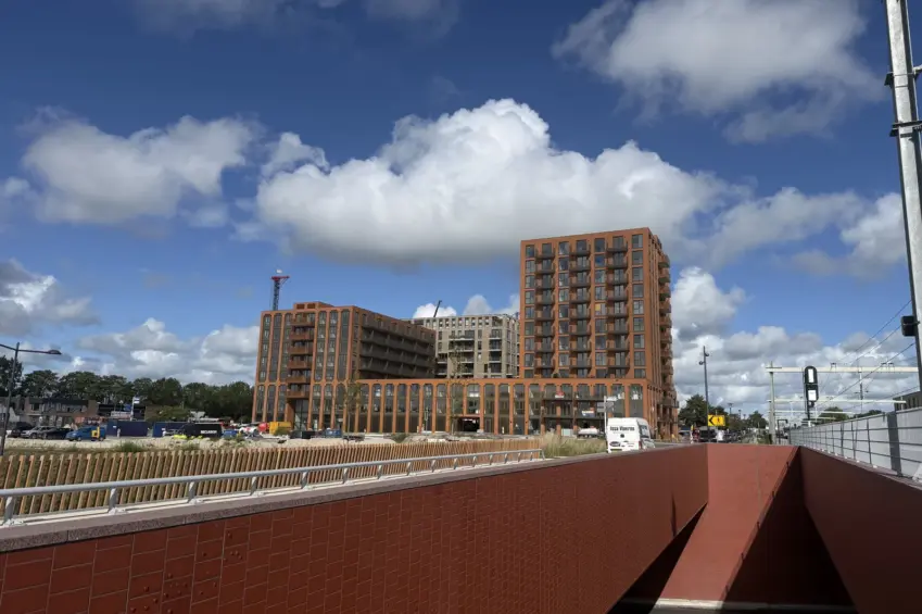 Nieuwe woongebouwen naast het spoor en een fietsonderdoorgang.